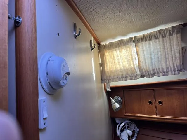 Slide: The Image of Interior cabin of 1999 Grand Banks Eastbay 38 with wooden cabinets and curtains. - 26