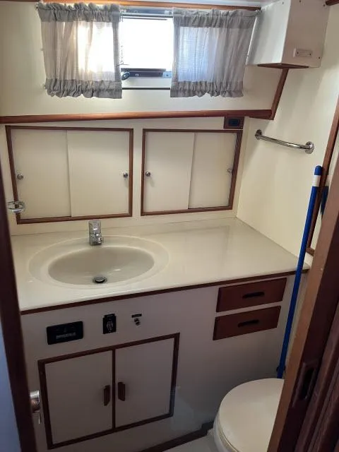 Slide: The Image of Bathroom interior of 1999 Grand Banks Eastbay 38 yacht with sink and storage cabinets. - 29