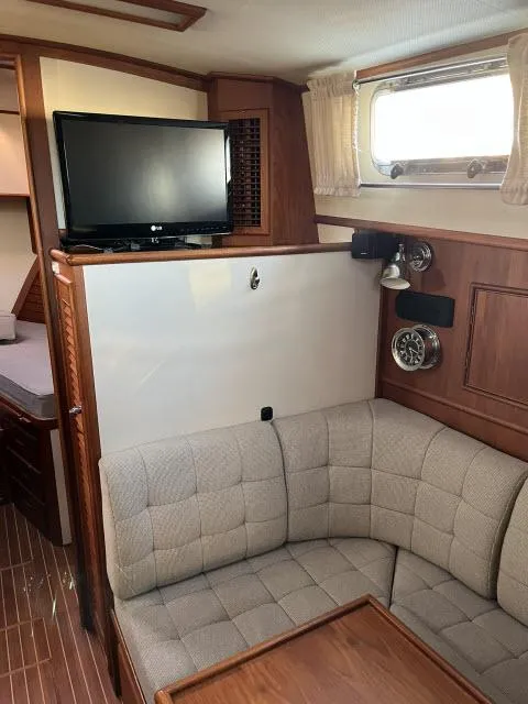 Slide: The Image of 1999 Grand Banks Eastbay 38 interior with cozy seating and TV. - 3