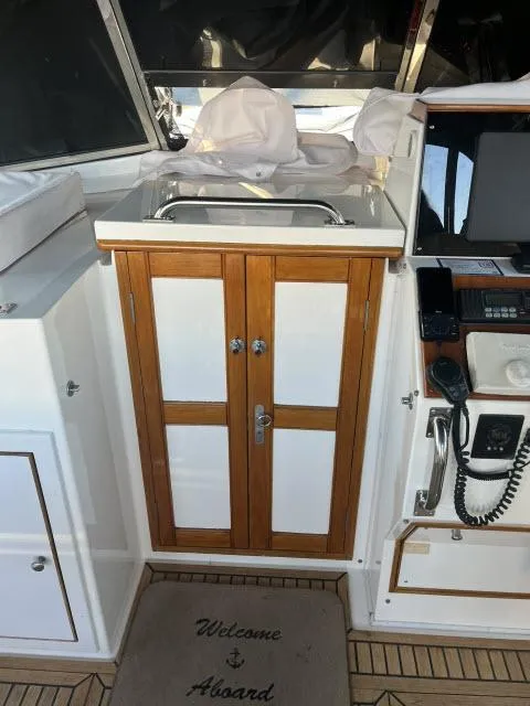 Slide: The Image of 1999 Grand Banks Eastbay 38 interior with wooden cabinet and nautical equipment. - 43