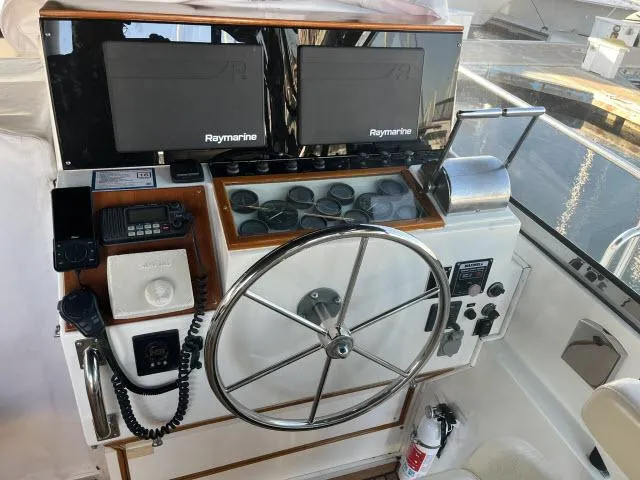 Slide: The Image of 1999 Grand Banks Eastbay 38 helm with Raymarine displays and steering wheel. - 44