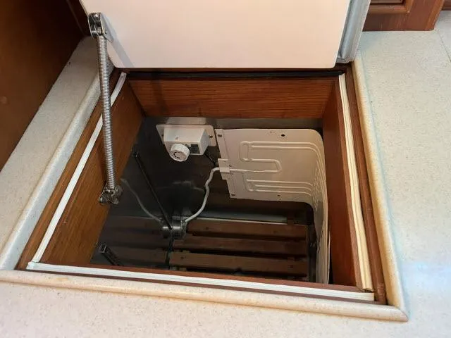 Slide: The Image of Storage compartment in 1999 Grand Banks Eastbay 38 yacht, featuring a built-in refrigeration unit. - 9