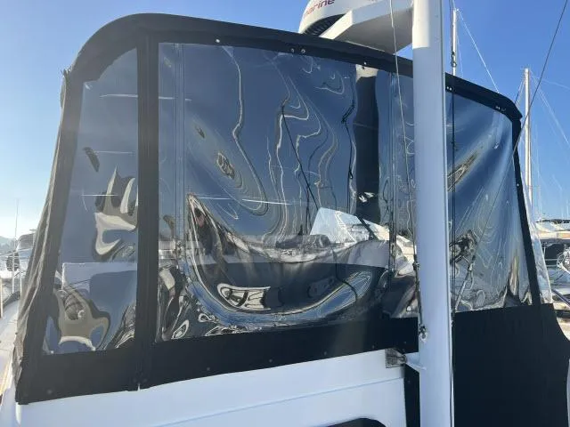 Slide: The Image of 1999 Grand Banks Eastbay 38 with clear enclosure panels in a marina setting. - 35