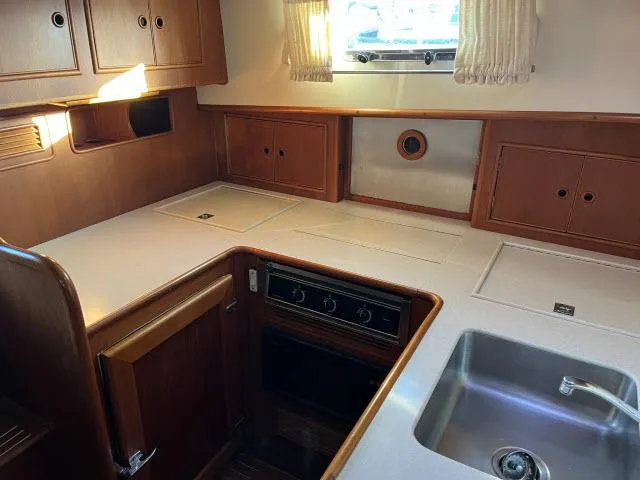 Slide: The Image of Interior of 1999 Grand Banks Eastbay 38 yacht kitchen with wooden cabinets and stainless steel sink. - 6