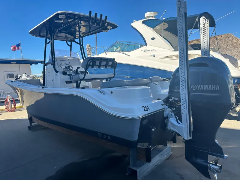 Slide: The Image of 2022 NauticStar Legacy 2302 boat with Yamaha engine, docked under clear blue sky. - 13