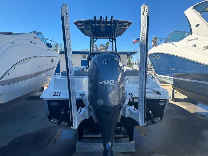 Slide: The Image of 2022 NauticStar Legacy 2302 boat with Yamaha 200 engine, docked between other boats. - 16