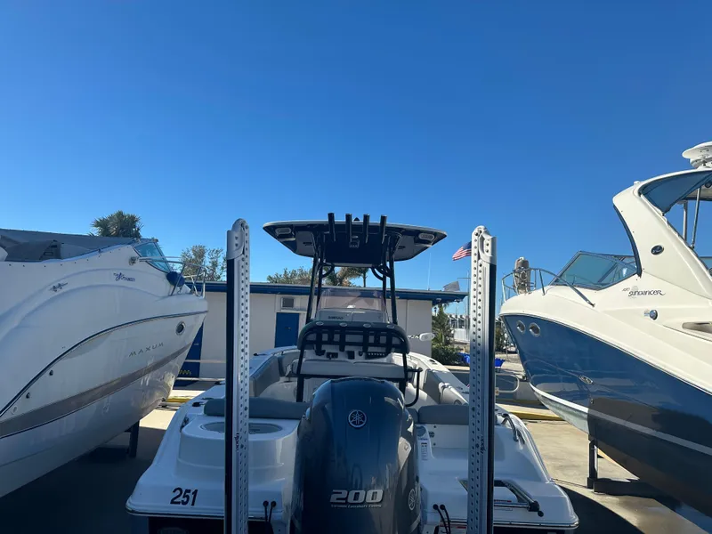 Slide: The Image of 2022 NauticStar Legacy 2302 boat docked between two other boats. - 17