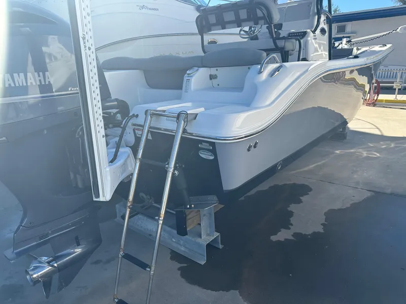 Slide: The Image of 2022 NauticStar Legacy 2302 boat with Yamaha engine and ladder, docked on concrete. - 22