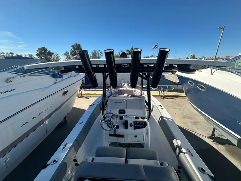 Slide: The Image of 2022 NauticStar Legacy 2302 boat interior with fishing rod holders and console. - 27