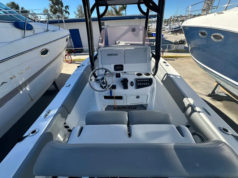 Slide: The Image of 2022 NauticStar Legacy 2302 boat interior with steering console and seating. - 29
