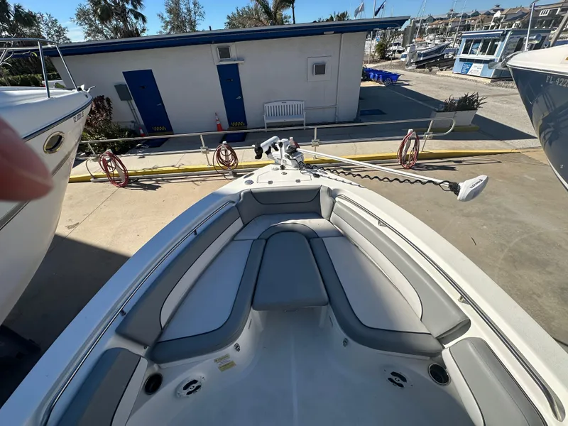 Slide: The Image of 2022 NauticStar Legacy 2302 boat interior with seating and equipment at a marina. - 39