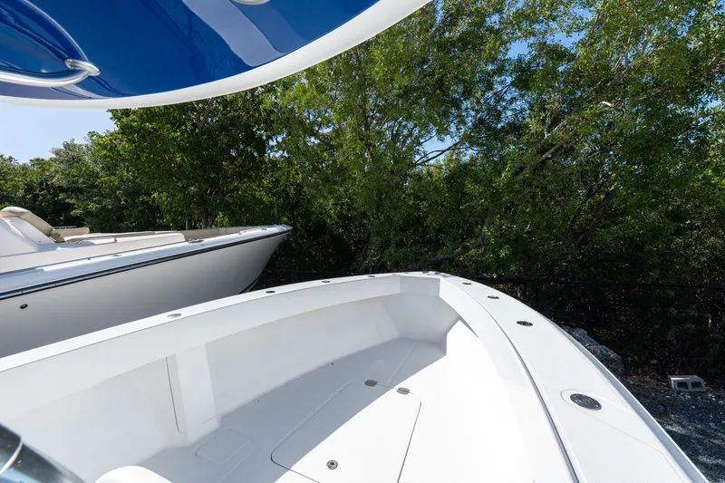 Slide: The Image of 2015 Bahama 34 boat with sleek white deck, surrounded by lush greenery. - 10