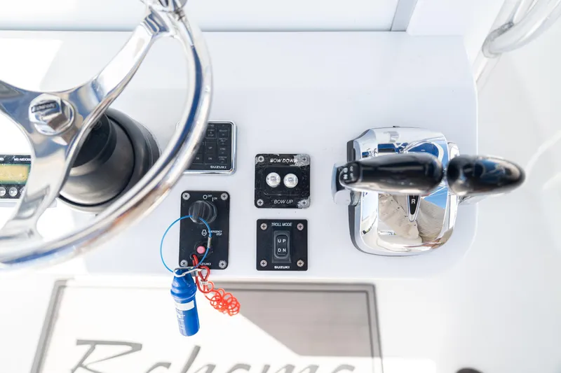 Slide: The Image of Control panel of a 2015 Bahama 34 boat with steering wheel and throttle. - 17