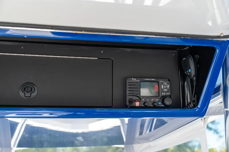 Slide: The Image of 2015 Bahama 34 boat console with radio equipment and storage compartment. - 18