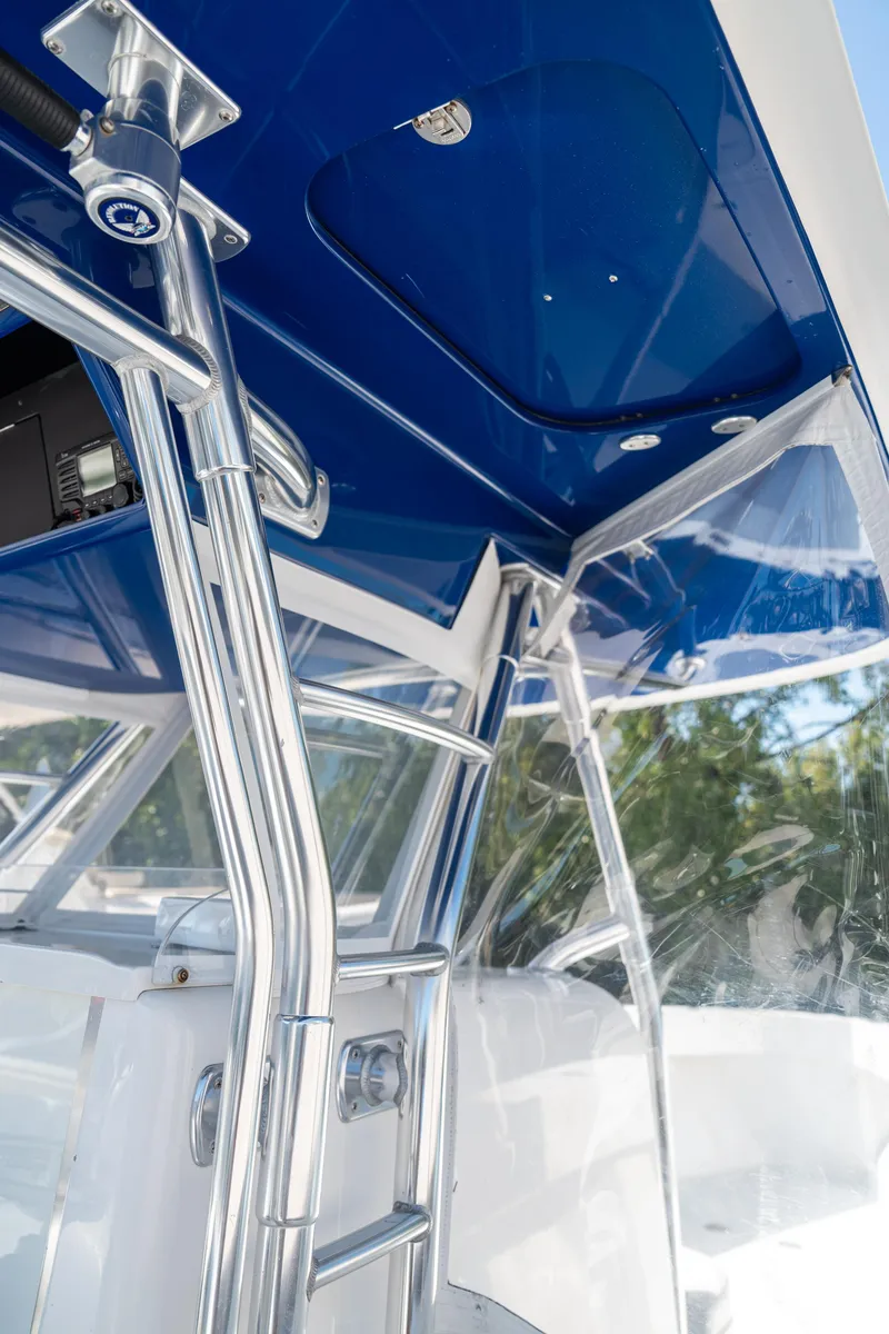 Slide: The Image of 2015 Bahama 34 boat interior with blue canopy and chrome ladder. - 19