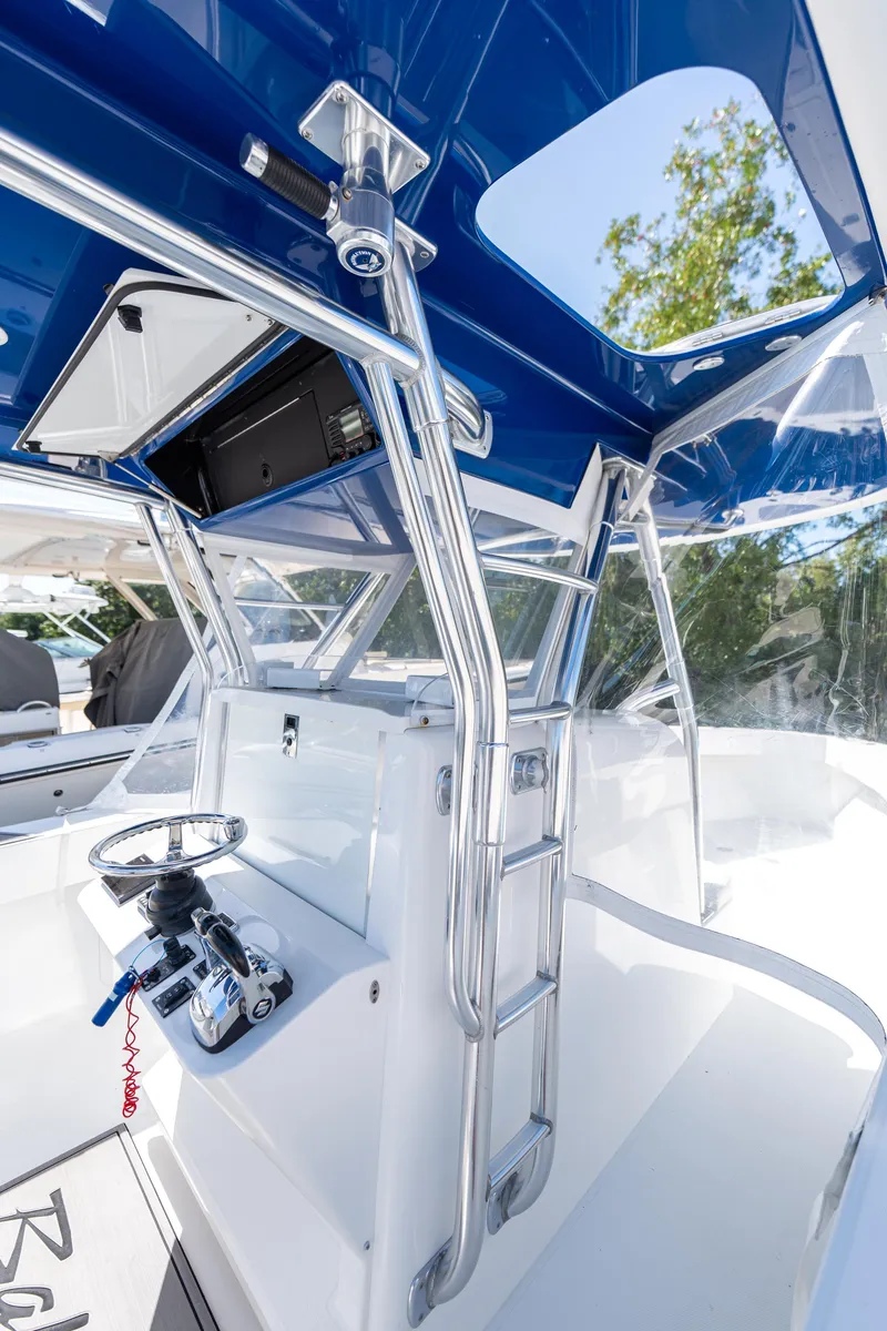 Slide: The Image of 2015 Bahama 34 boat interior with steering wheel and ladder, featuring blue accents. - 21