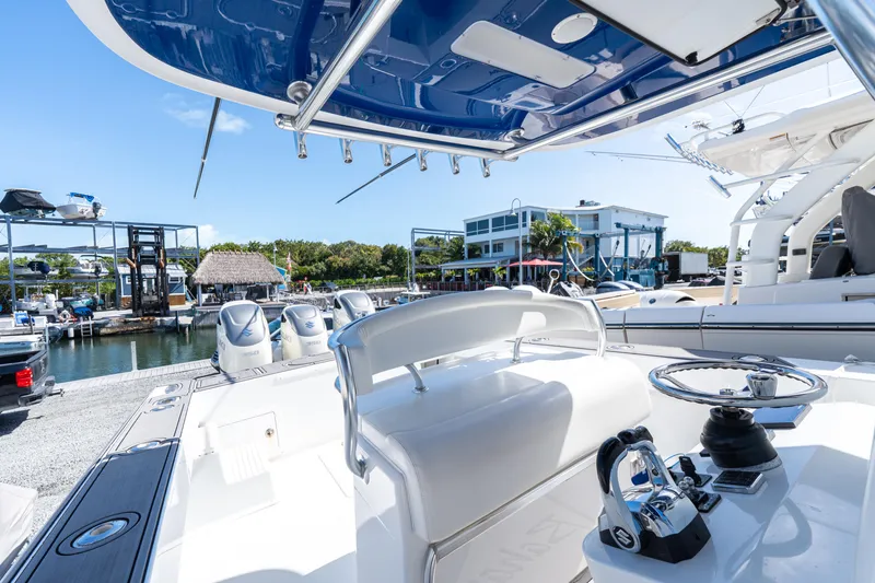 Slide: The Image of 2015 Bahama 34 boat interior with helm, docked at marina. - 23