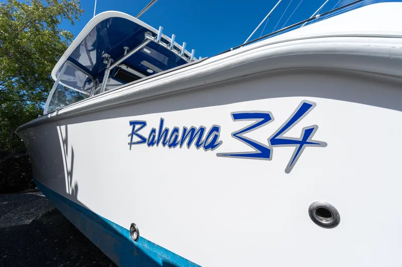Slide: The Image of 2015 Bahama 34 boat with sleek design and blue accents under clear sky. - 4