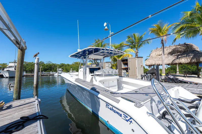Slide: The Image of 2015 Bahama 34 boat docked in sunny marina with palm trees. - 44