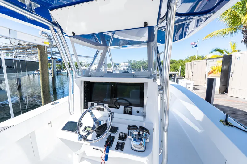 Slide: The Image of 2015 Bahama 34 boat cockpit with steering wheel and navigation equipment. - 47