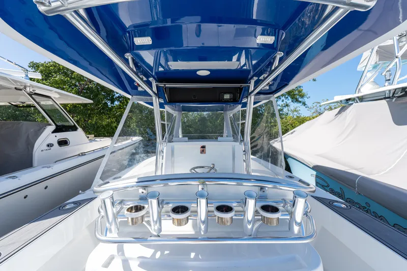 Slide: The Image of 2015 Bahama 34 boat cockpit with blue canopy and rod holders. - 6