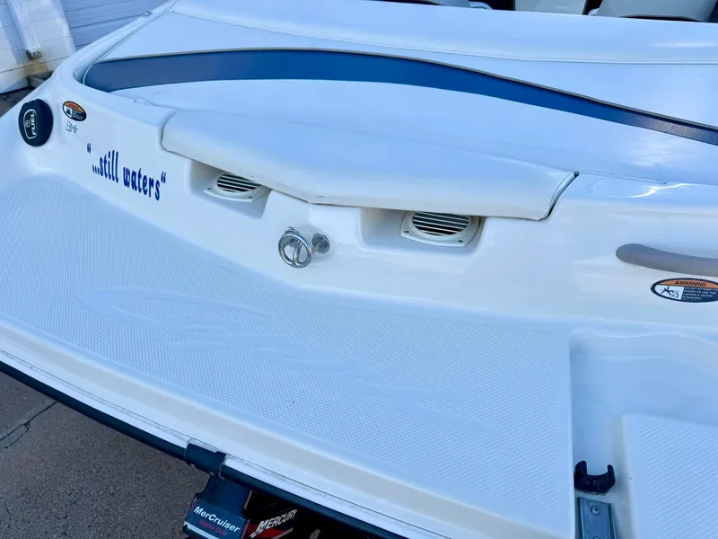 Slide: The Image of 2002 Bayliner 185 BR boat stern with "still waters" text, white and blue design. - 12