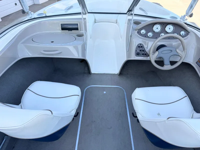 Slide: The Image of 2002 Bayliner 185 BR boat interior with white seats and dashboard. - 15