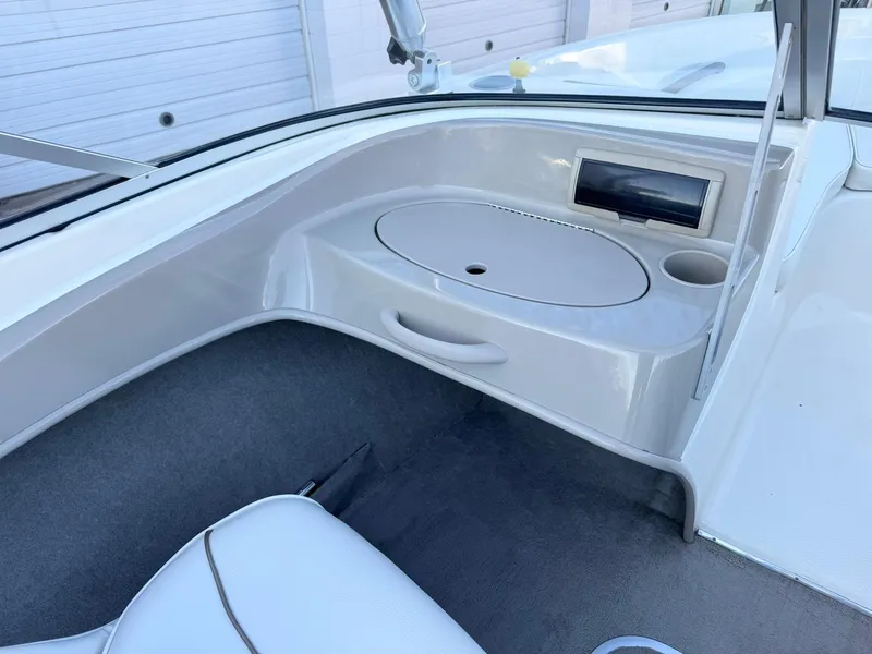 Slide: The Image of 2002 Bayliner 185 BR boat interior with storage compartment and cup holder. - 17