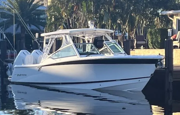 Slide: The Image of 2023 Blackfin 302 DC boat docked in a serene marina setting. - 2