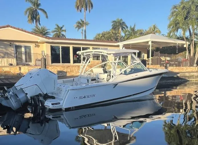 Slide: The Image of 2023 Blackfin 302 DC boat docked by a waterfront house with palm trees. - 4