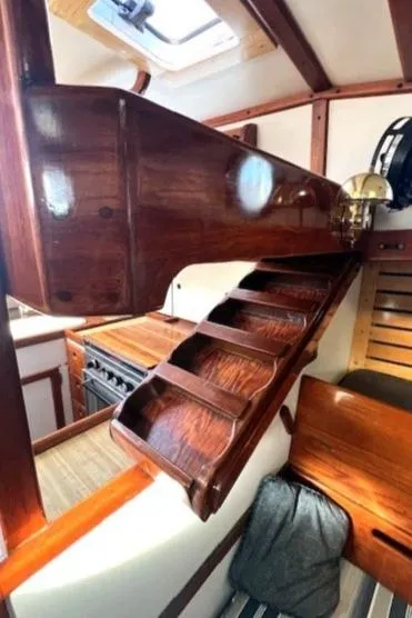 Slide: The Image of Interior of 1980 Kaiser Gale Force 34 sailboat with wooden stairs and compact kitchen. - 34