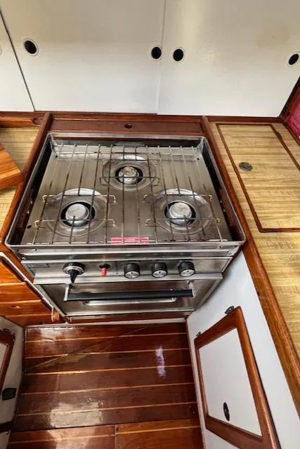 Slide: The Image of 1980 Kaiser Gale Force 34 yacht kitchen with a three-burner stove and wooden cabinetry. - 39