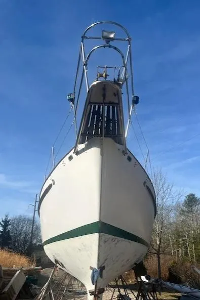 Slide: The Image of 1980 Kaiser Gale Force 34 sailboat on land, viewed from the front under a clear blue sky. - 5
