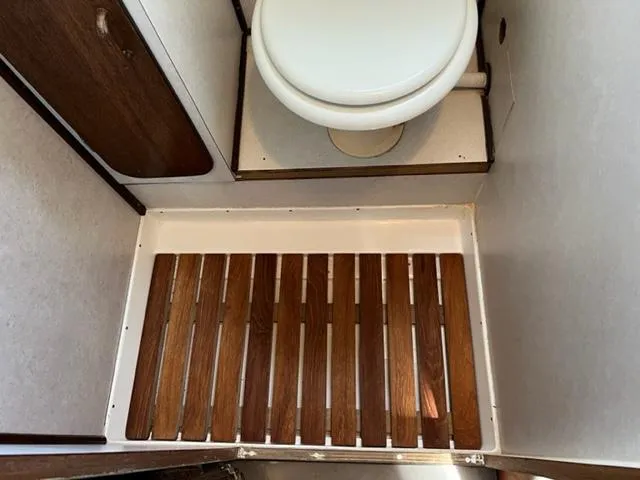 Slide: The Image of 1968 Chris-Craft 31 Commander bathroom with wooden floor and white toilet. - 14