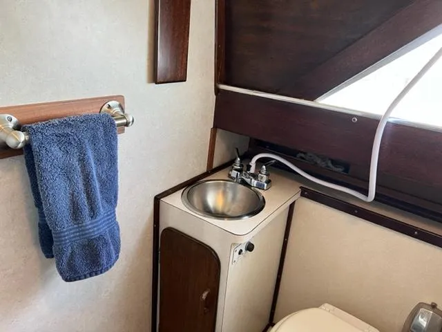 Slide: The Image of 1968 Chris-Craft 31 Commander bathroom with sink, towel, and wooden accents. - 15