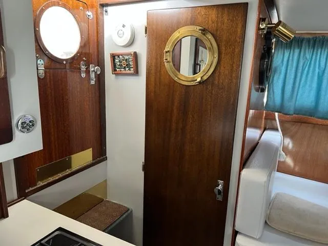 Slide: The Image of 1968 Chris-Craft 31 Commander cabin interior with wood paneling and porthole. - 17