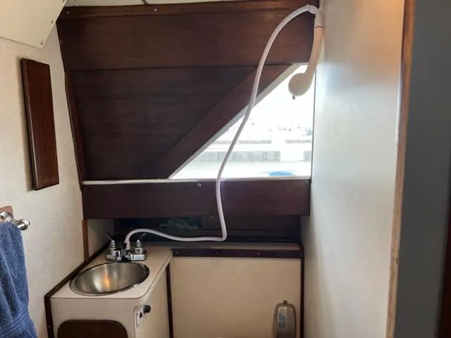 Slide: The Image of 1968 Chris-Craft 31 Commander bathroom with sink and showerhead. - 18