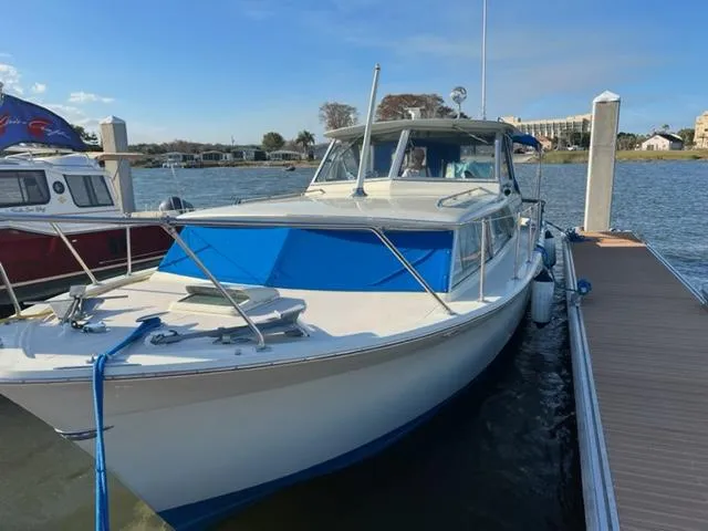Slide: The Image of 1968 Chris-Craft 31 Commander docked by the water on a sunny day. - 2