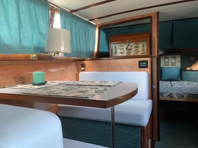 Slide: The Image of Interior of 1968 Chris-Craft 31 Commander with teal curtains and cozy seating area. - 5