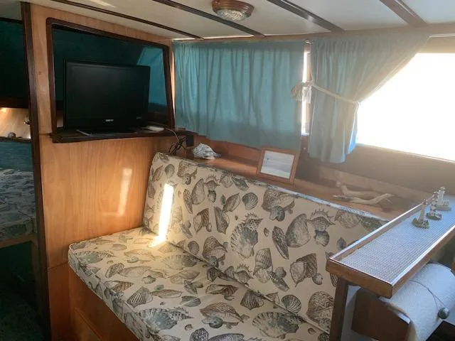 Slide: The Image of 1968 Chris-Craft 31 Commander interior with patterned seating, TV, and blue curtains. - 7