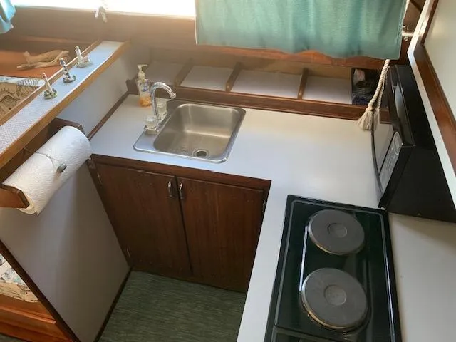 Slide: The Image of 1968 Chris-Craft 31 Commander kitchen with sink, stove, and microwave. - 9