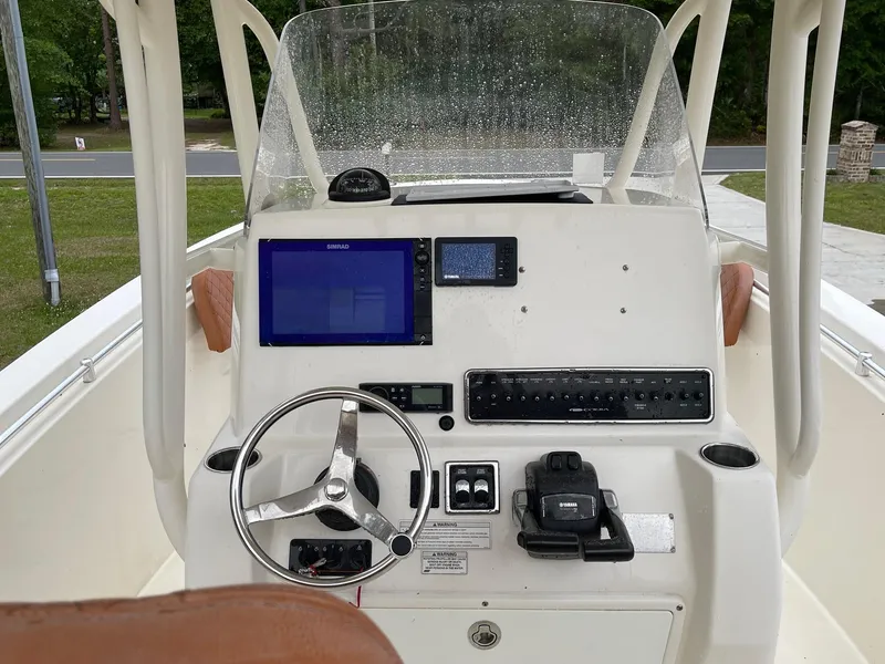 Slide: The Image of 2017 Cobia 261 Center Console boat dashboard with steering wheel and navigation equipment. - 25