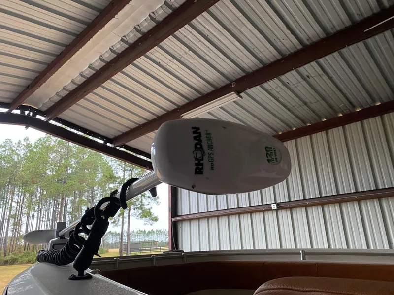 Slide: The Image of 2017 Cobia 261 Center Console boat under metal roof with Rodan trolling motor. - 32