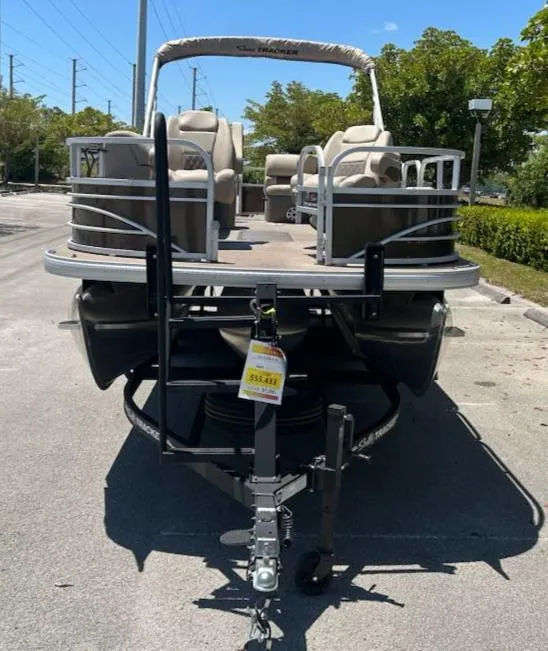 Slide: The Image of 2025 Sun Tracker Sportfish 24 XP3 pontoon boat on trailer, parked outdoors. - 3