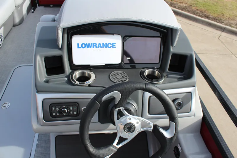 Slide: The Image of 2025 Regency 230 DL3 boat cockpit with steering wheel and Lowrance display. - 12