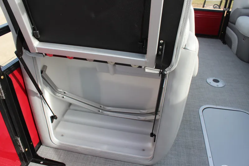 Slide: The Image of 2025 Regency 230 DL3 pontoon boat with open storage compartment and cushioned seating. - 20