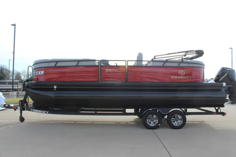 Slide: The Image of 2025 Regency 230 DL3 pontoon boat with red exterior on a trailer. - 4