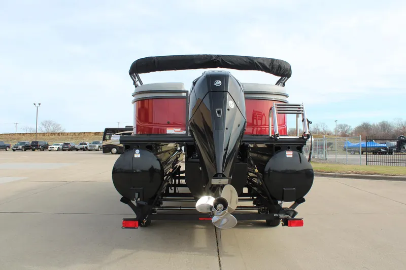Slide: The Image of 2025 Regency 230 DL3 pontoon boat with red exterior at dealership, clear sky background. - 6