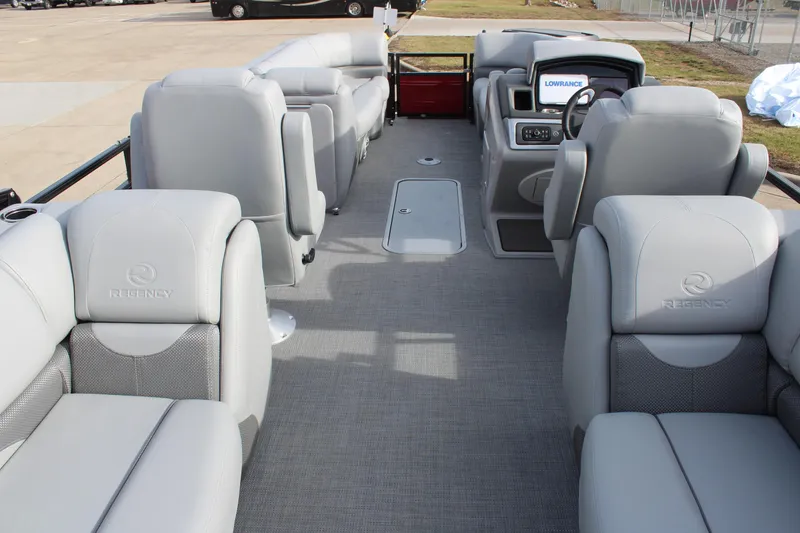 Slide: The Image of 2025 Regency 230 DL3 pontoon boat with outboard motor, parked outdoors. - 7