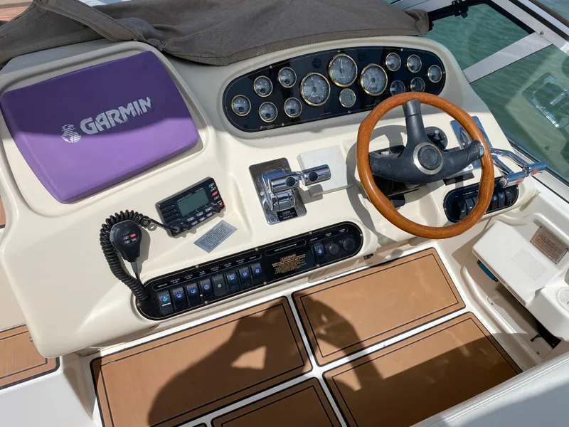 Slide: The Image of Cruisers 3672 2000 boat dashboard with Garmin navigation and wooden steering wheel. - 11